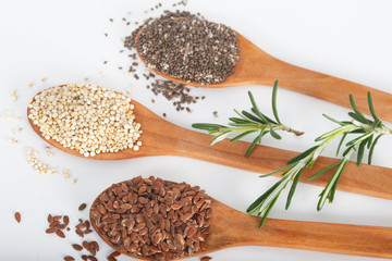 Healthy dried seed used as ingredients in cooking. Linseed, chia and quinoa in wooden spoons.