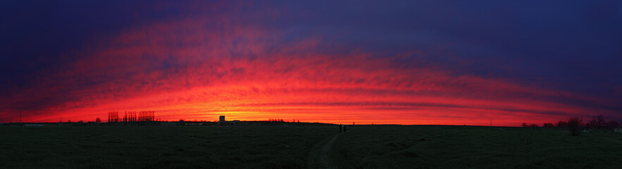 Fototapeta premium Couple is going home through the colorful sunset cloudscape arc