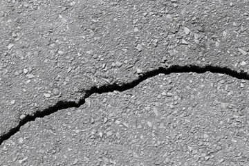 Asphalt track with a crack in a broken line.