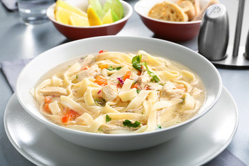 Chicken noodle soup in plate on kitchen table