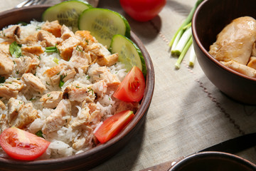 Fototapeta na wymiar Delicious rice with chicken and vegetables in bowl on table