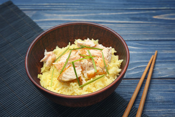 Plate with chicken and rice on wicker mat