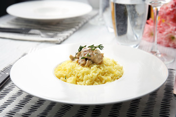 Plate with rice and chicken on table