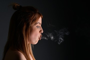 young woman with cigarette, smoking concept on black background