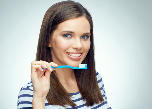 Smiling girl with brace brushing teeth.