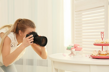 Young woman photographing food indoors