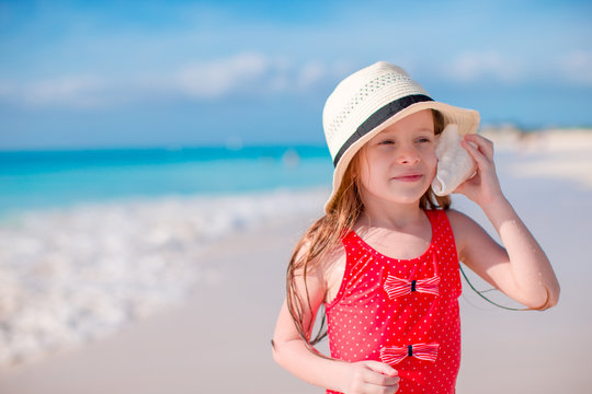 Portrait of little cute girl with a big seashell