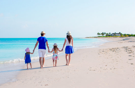 Happy beautiful family of four on a tropical beach vacation