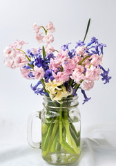 Different hyacinth flowers in glass jar