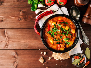 Goulash in ceramic bowl on wooden background. Traditional hungarian soup. - obrazy, fototapety, plakaty