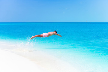 Young man plunging into the turquoise sea