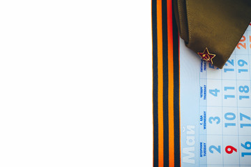 Military cap with orange and black striped ribbon symbol on May 9 with calendar