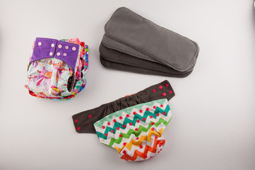 Baby cloth panties and diaper inserts on white background