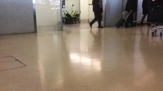 Low Angle Shot Passengers arrival With Luggage In Airport. Passengers arrival after pick up bags at an international airport