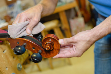 artisan luthier polishing violin