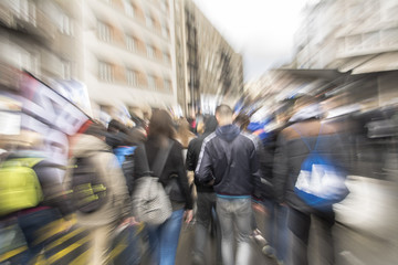 Crowd of young people walking in big city.De-focused and abstract image with zoom-burst effect