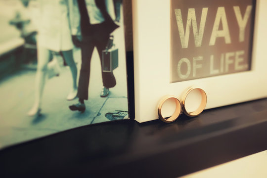 Wedding rings on the background of the print "life journey", and an old photo of a couple in love walking along the boulevard