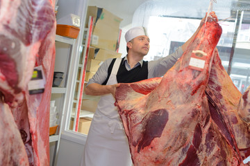 Butcher with animal carcass