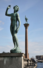 Statue of a naked man and Engelbrecht monument in Stockholm.