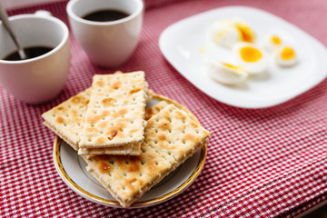 Two cups of coffee, cracker, egg, breakfast