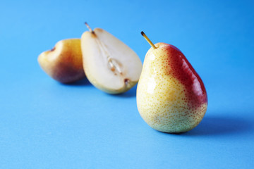 Whole fresh ripe pears fruits on blue background, modern style food picture, summer wallpaper design