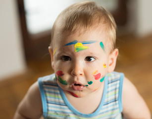 Baby messed with colorful paint