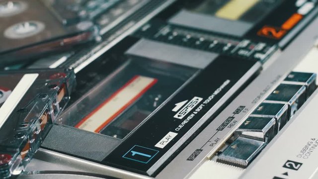 Pushing Play and Stop Button on the Vintage Audio Cassette Player. Pushing a Finger Button Play, Stop on a Tape Recorder. Man finger presses playback control buttons.