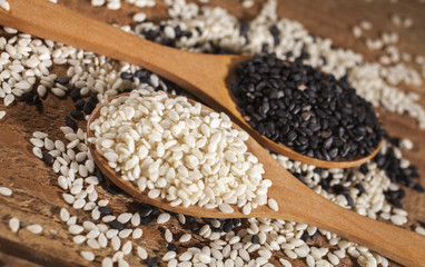 Fresh black and white sesame seeds in spoons