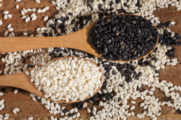 Fresh black and white sesame seeds in spoons