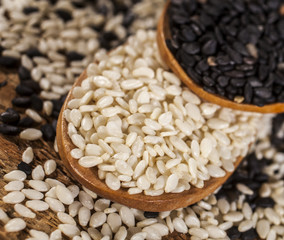 Fresh black and white sesame seeds in spoons