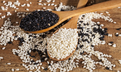 Fresh black and white sesame seeds in spoons