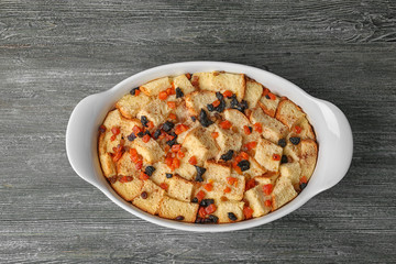 Freshly baked bread pudding in casserole dish on wooden table