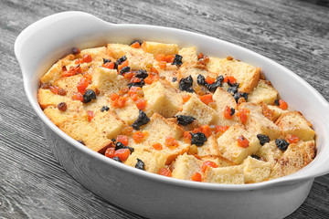 Freshly baked bread pudding in casserole dish on wooden table