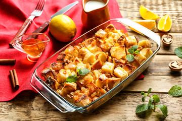 Delicious bread pudding with raisins in glass dish on table
