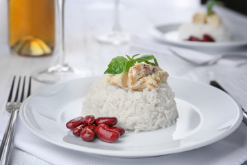 Delicious dish with chicken, rice and beans on white plate