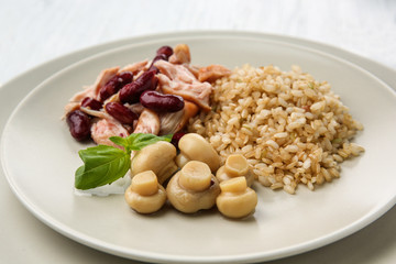 Tasty dish with chicken, rice, beans and mushrooms on plate