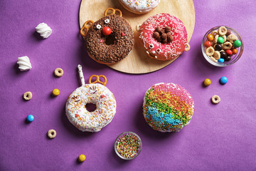 Funny decorated donuts on table