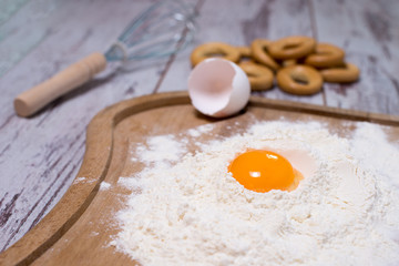 Baking concept. Sprinkled flour and eggs on wooden cutting board, cooking ingredients. Prepare for making yeast dough. Top view, copy space