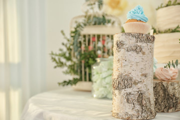 Wooden stand with tasty cupcake on table served for party