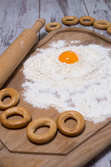 Baking concept. Sprinkled flour and eggs on wooden cutting board, cooking ingredients. Prepare for making yeast dough. Top view, copy space
