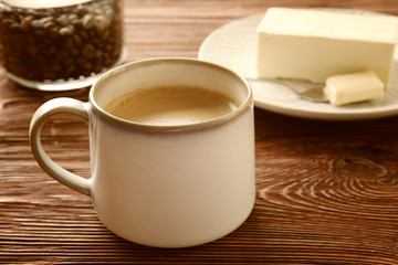 Cup of tasty butter coffee on wooden table