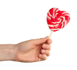 Female hand with tasty colorful lollipop on white background