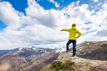 Obraz premium A woman is standing on the summit, beautiful sunny day.