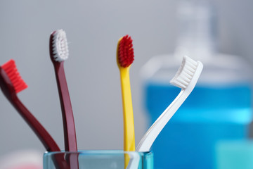 Cup with toothbrushes on blurred background