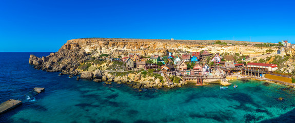 Il-Mellieha, Malta - Panoramic skyline view of the beautiful Popeye Village at Anchor Bay. This village was the set in Robert Altman's famous movie 'Popeye' with Robin Williams in the main role. - obrazy, fototapety, plakaty