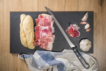 Iberian Acorn Ham Sandwich with knife and garlic bulb