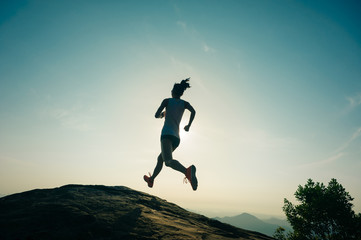 Fototapeta na wymiar Young fitness woman trail runner running at mountain top