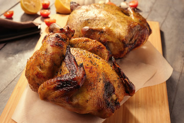 Roasted beer can chicken on wooden board, closeup