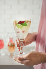 Woman holding glass of delicious wine spritzer