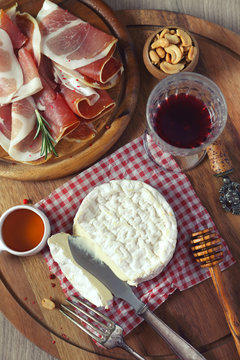 Camembert cheese, cold cuts and  red wine. Toned image